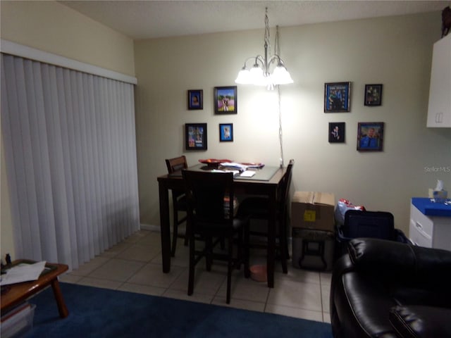 tiled dining room with an inviting chandelier