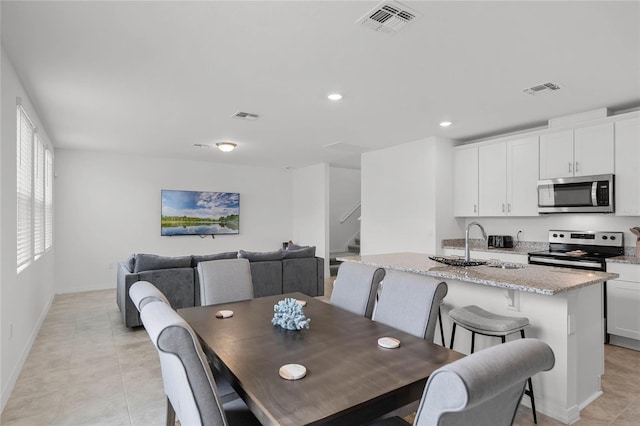 dining area featuring sink and light tile patterned floors