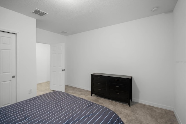 bedroom featuring a textured ceiling and a closet