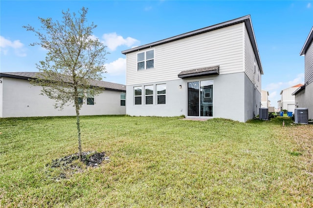 rear view of property featuring a lawn and cooling unit