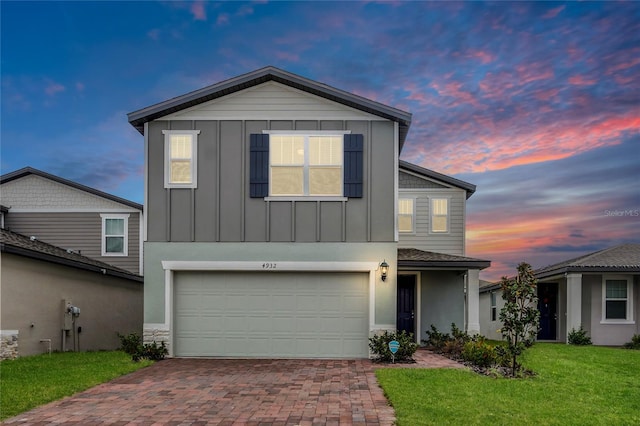 4932 Mainsail St, Haines City, FL 33844 - view of front facade featuring a garage, board and batten siding, decorative driveway, and a yard