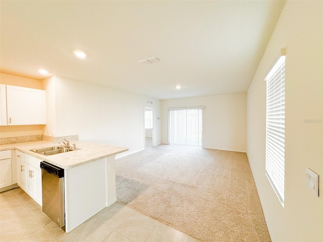 kitchen with light carpet, sink, stainless steel dishwasher, white cabinetry, and kitchen peninsula