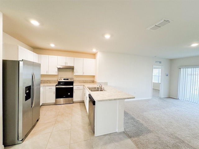 kitchen featuring kitchen peninsula, sink, appliances with stainless steel finishes, light colored carpet, and white cabinetry