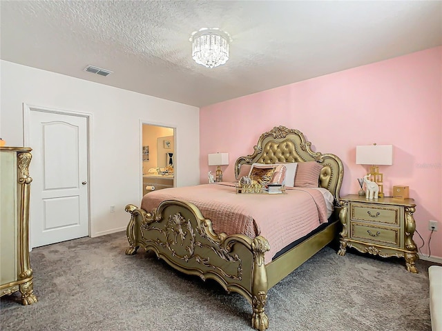 carpeted bedroom with a textured ceiling and connected bathroom