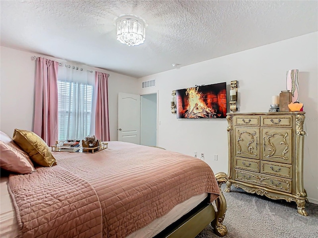 bedroom featuring carpet flooring and a textured ceiling