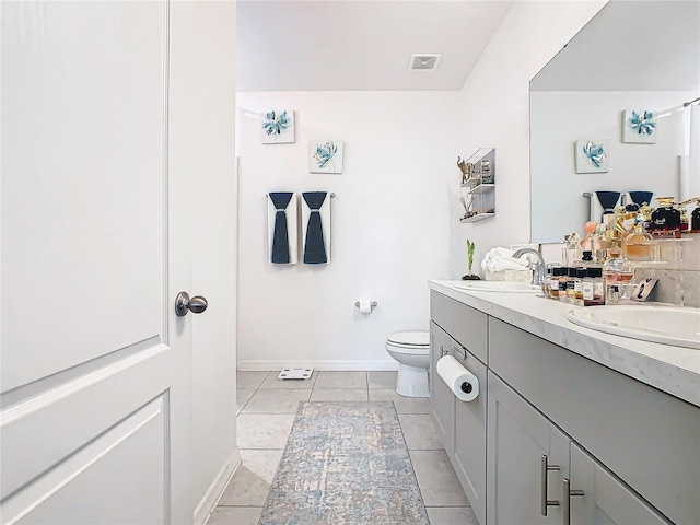 bathroom featuring toilet, vanity, and tile patterned floors