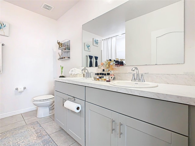 bathroom with tile patterned flooring, vanity, and toilet