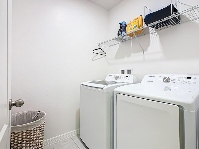 laundry area featuring light tile patterned floors and washing machine and clothes dryer