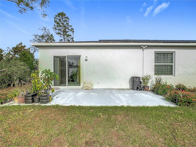 rear view of house featuring solar panels, a patio area, and a yard