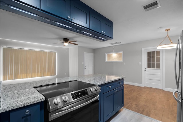 kitchen with light stone countertops, appliances with stainless steel finishes, blue cabinets, ceiling fan, and light hardwood / wood-style flooring