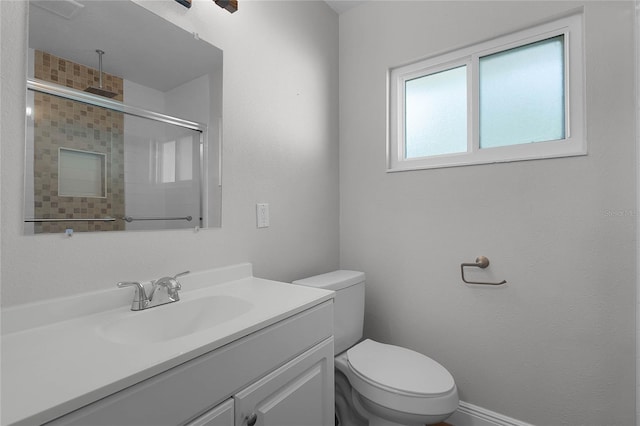 bathroom featuring toilet, vanity, and walk in shower