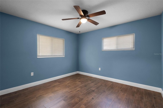 empty room with ceiling fan and dark wood-type flooring