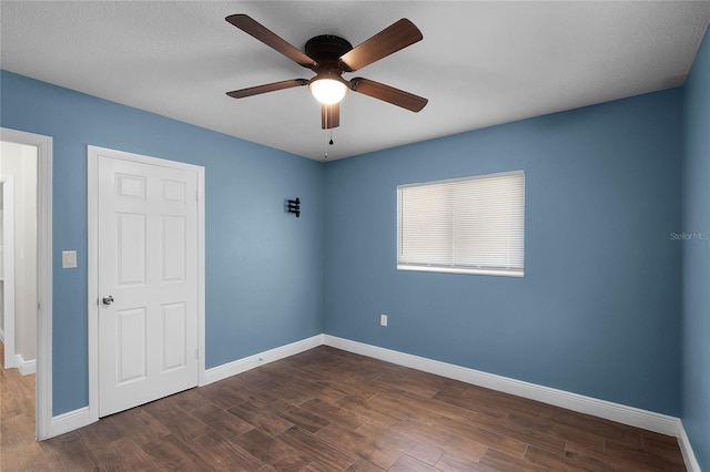 unfurnished bedroom with ceiling fan and dark wood-type flooring