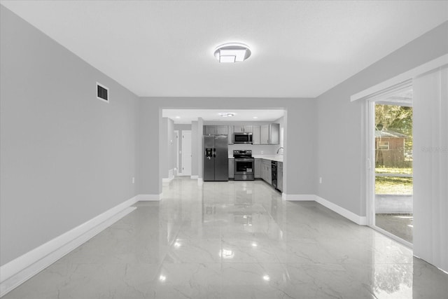 unfurnished living room featuring sink