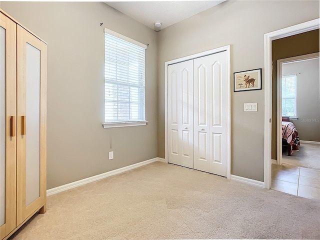 unfurnished bedroom with light carpet and a closet