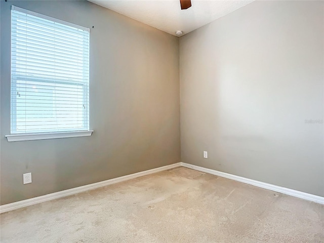 empty room with ceiling fan and light carpet