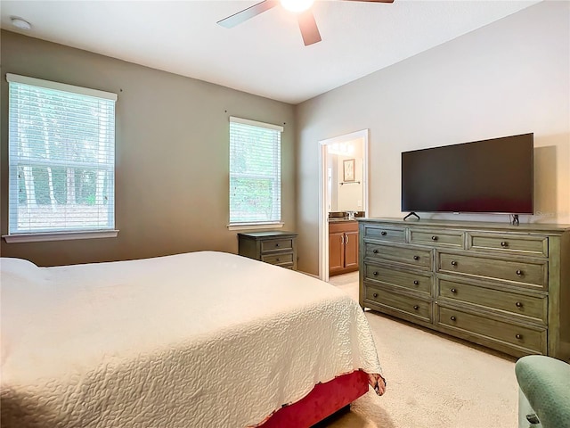 carpeted bedroom featuring ceiling fan and ensuite bath