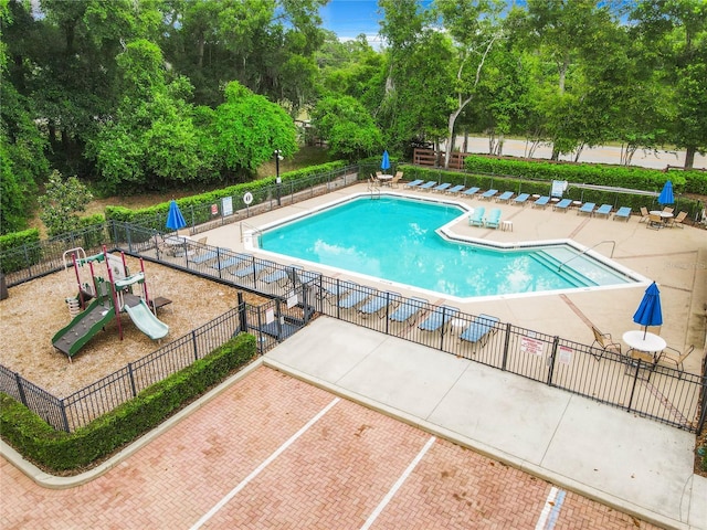 view of pool featuring a playground and a patio area