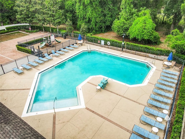 view of swimming pool featuring a playground