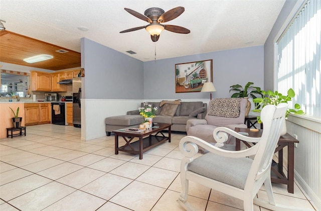 tiled living room featuring ceiling fan