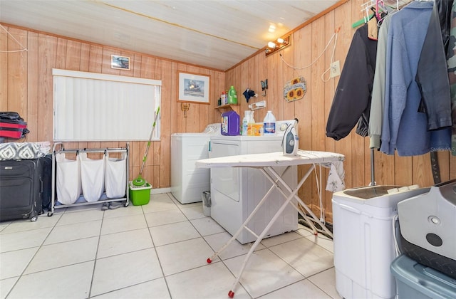 laundry area with light tile patterned floors, washing machine and dryer, wooden walls, and wood ceiling