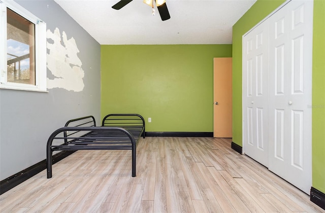 bedroom featuring ceiling fan, light hardwood / wood-style flooring, and a closet