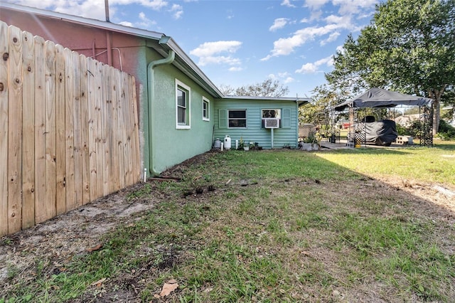 exterior space featuring a lawn, cooling unit, and a gazebo