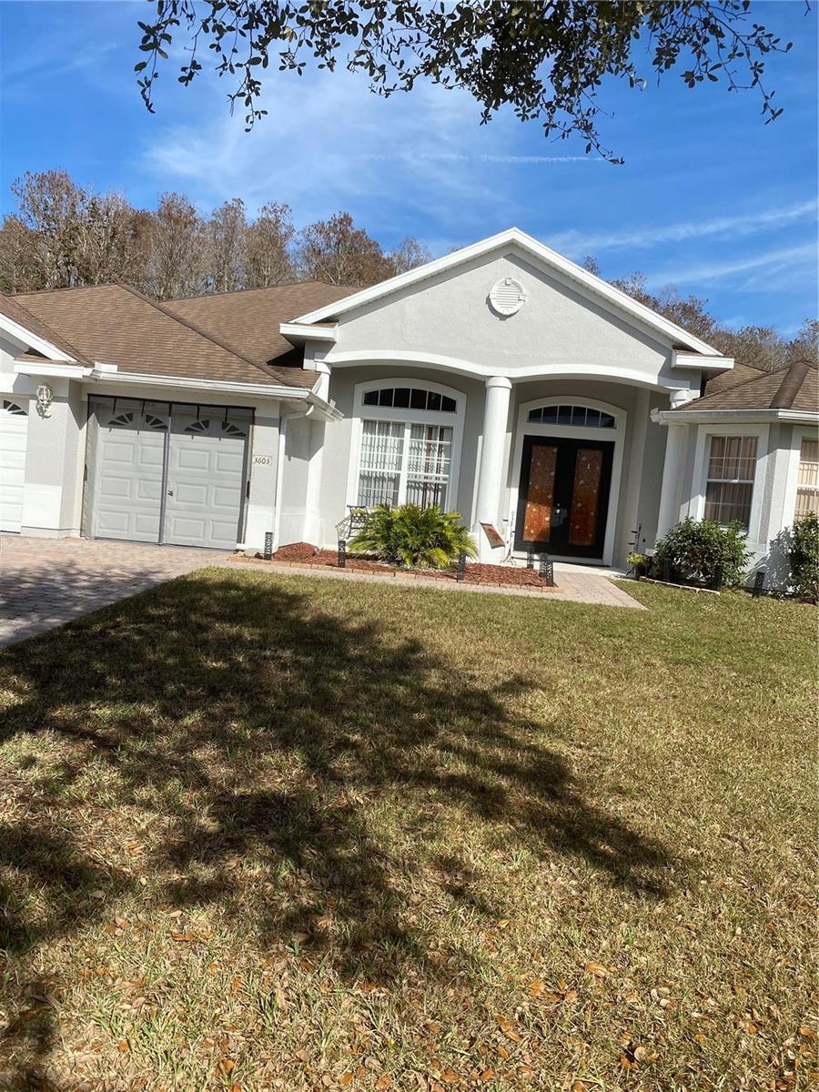 ranch-style house with french doors, a garage, and a front lawn