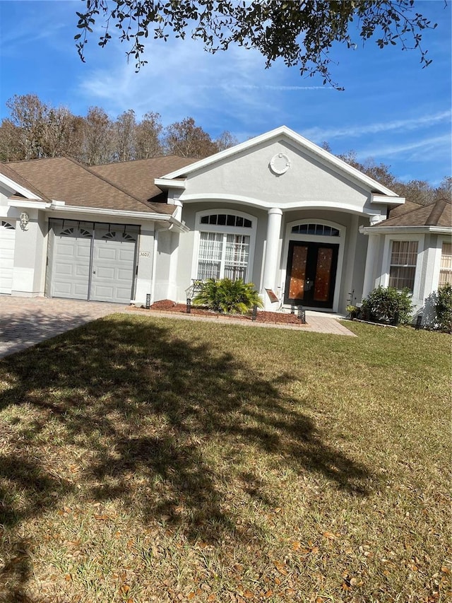 ranch-style house with french doors, a garage, and a front lawn