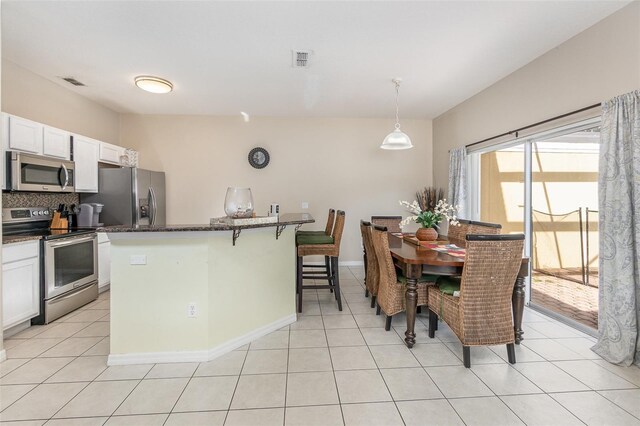 kitchen with white cabinets, a center island, stainless steel appliances, and hanging light fixtures