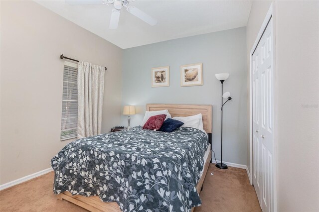 carpeted bedroom with ceiling fan and a closet