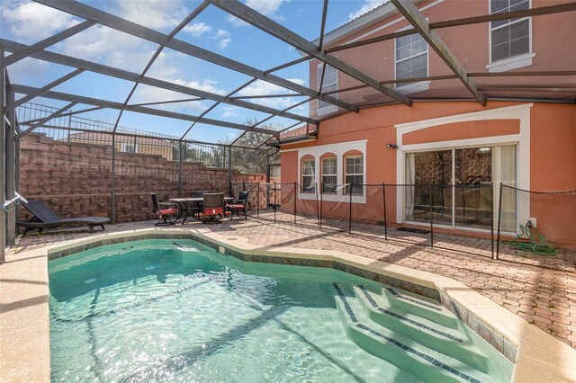 view of swimming pool with glass enclosure and a patio area