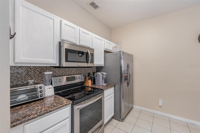 kitchen with backsplash, dark stone countertops, white cabinetry, and appliances with stainless steel finishes