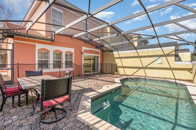 view of swimming pool featuring a lanai and a patio