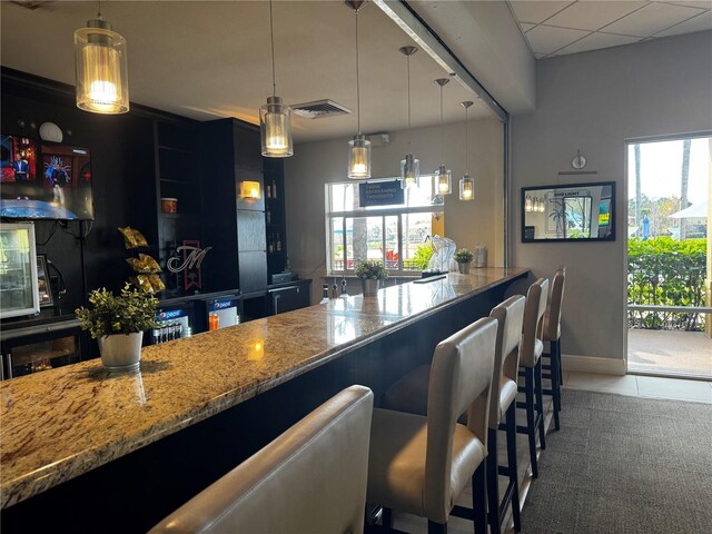 kitchen featuring light stone countertops and hanging light fixtures