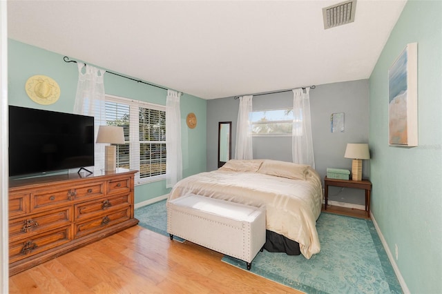 bedroom featuring wood-type flooring and multiple windows