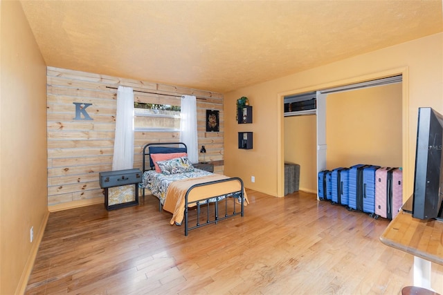 bedroom featuring hardwood / wood-style floors and wood walls