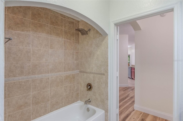 bathroom featuring hardwood / wood-style floors and tiled shower / bath