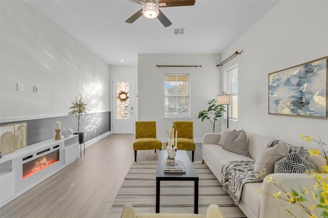 living room featuring ceiling fan and light wood-type flooring