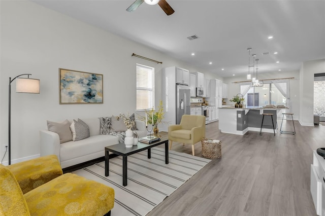 living room featuring ceiling fan and light wood-type flooring