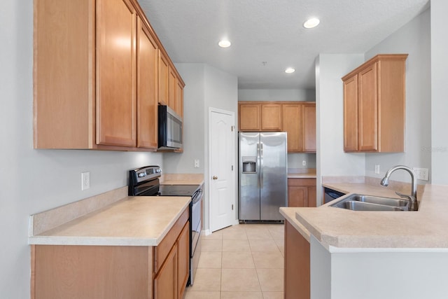 kitchen featuring light countertops, recessed lighting, appliances with stainless steel finishes, a peninsula, and a sink