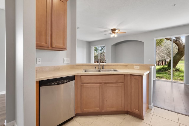 kitchen featuring a sink, a peninsula, light countertops, dishwasher, and ceiling fan