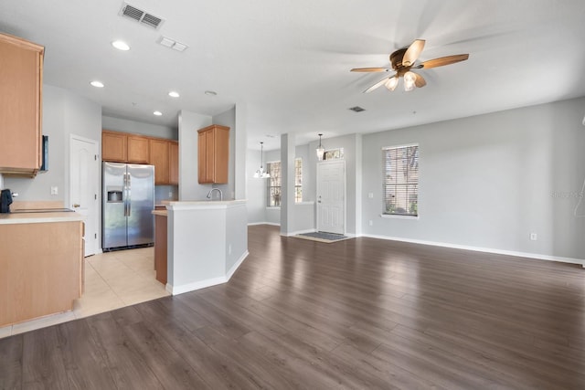 kitchen featuring open floor plan, visible vents, light wood-type flooring, and stainless steel refrigerator with ice dispenser