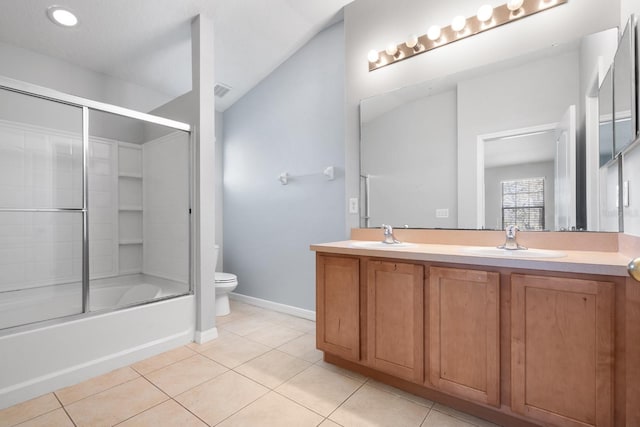 bathroom featuring tile patterned floors, double vanity, toilet, and a sink