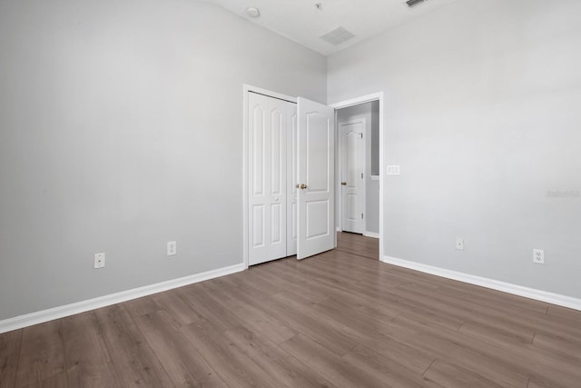 spare room featuring visible vents, baseboards, and wood finished floors