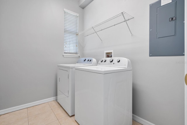 washroom featuring baseboards, electric panel, laundry area, light tile patterned floors, and separate washer and dryer