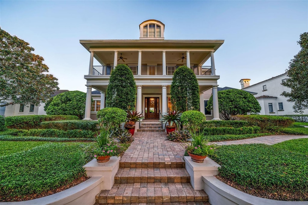 view of front of house featuring ceiling fan and a balcony