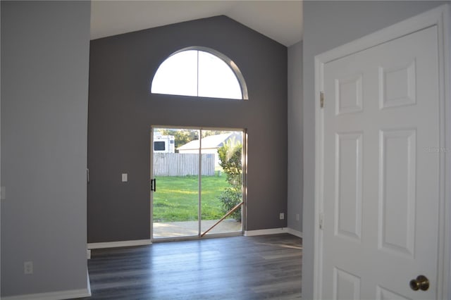 unfurnished room featuring dark wood-type flooring and lofted ceiling