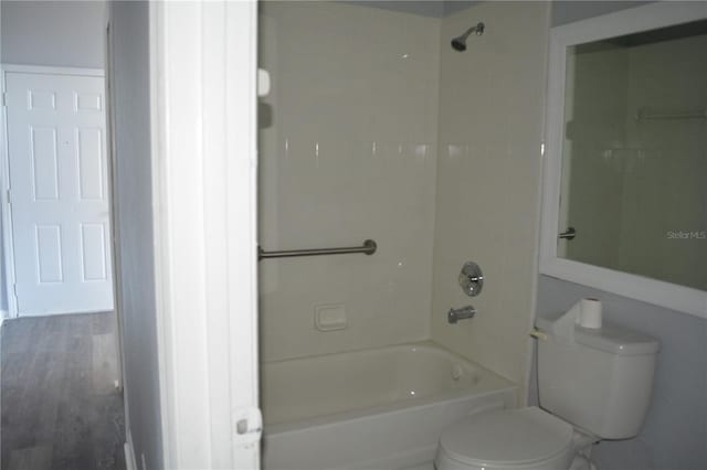 bathroom featuring toilet, tiled shower / bath, and hardwood / wood-style flooring