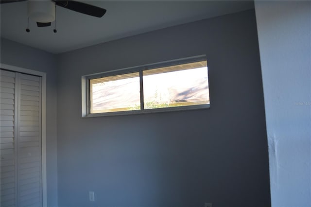 unfurnished bedroom with ceiling fan and a closet